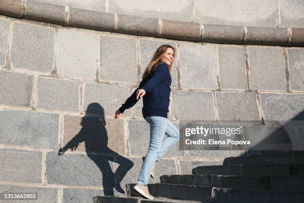 young confidence woman wearing casual clothes walking at the urban staircase up and down - walking up stairs stockfoto's en -beelden