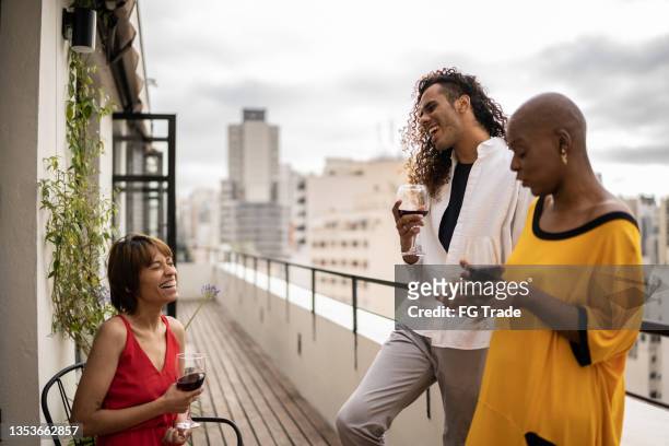 amigos falando e bebendo em um telhado - older woman younger man - fotografias e filmes do acervo
