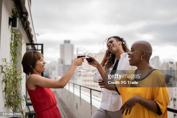 friends toasting on a rooftop - rooftop party stock pictures, royalty-free photos & images