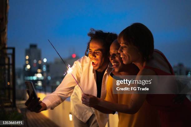 amici che fanno il conto alla rovescia a capodanno in una videochiamata sullo smartphone di casa - new year's eve foto e immagini stock