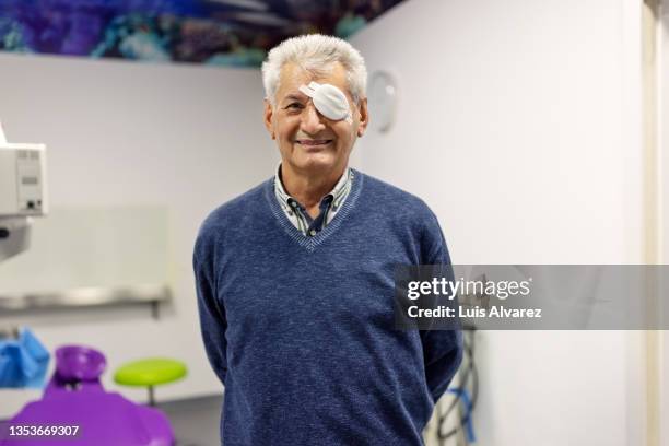 portrait of a senior man with eye bandage after cataract operation - oftalmologista imagens e fotografias de stock