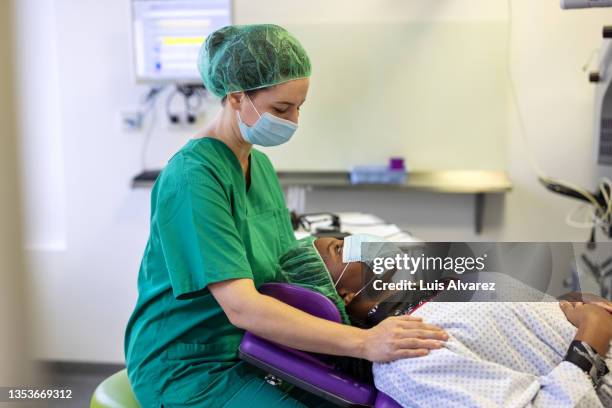 doctor preparing patient for eye surgery in operating room - compassionate eye stock-fotos und bilder