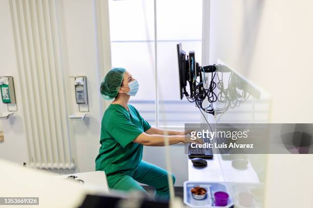 eye surgeon working on computer in operation room - critical care bildbanksfoton och bilder