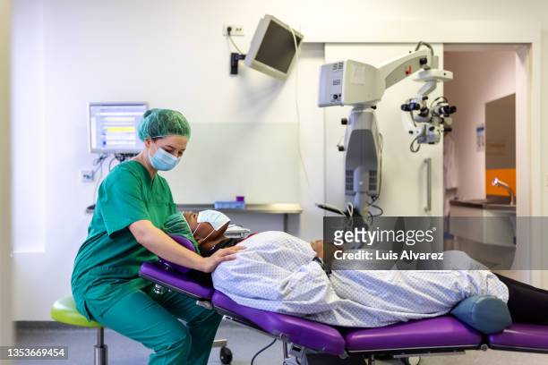 ophthalmologist with woman patient in the operating room - compassionate eye stockfoto's en -beelden