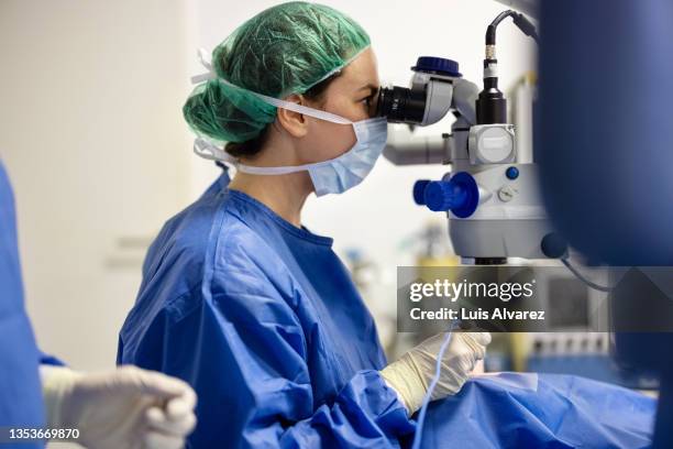 surgeon using magnifier to perform cataract surgery - operation stock-fotos und bilder