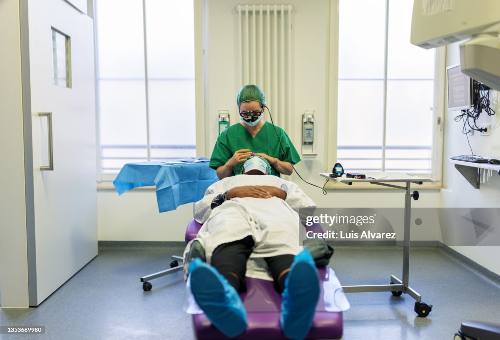 Surgeon operating eye of a woman patient in hospital