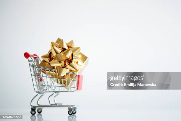 shopping cart with present box - excess product stock pictures, royalty-free photos & images