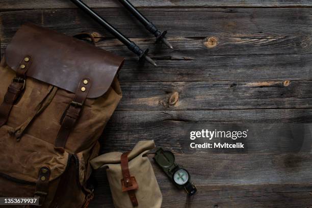 trekkingausrüstung auf holzhintergrund - rucksack mit wanderschuhen stock-fotos und bilder