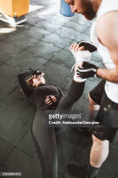 female athlete in pain getting help with hurt leg from male colleague - massage funny stock pictures, royalty-free photos & images