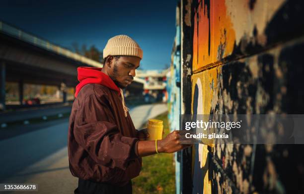 street artist drawing graffiti on the wall. - male artist stock pictures, royalty-free photos & images