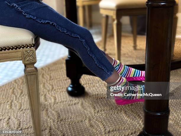 mixed-race young girl leans back in chair during online school at home - table leg stock pictures, royalty-free photos & images