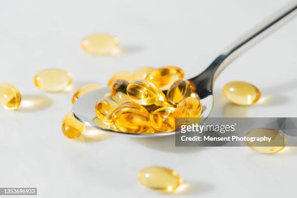 food supplement omega 3 in a spoon, medical supplements and vitamins d - cod liver oil stock pictures, royalty-free photos & images