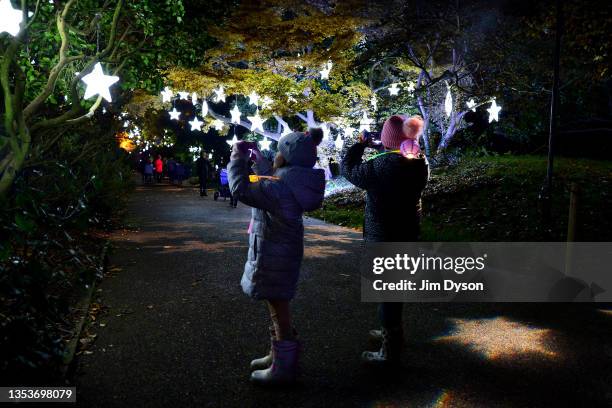 Children take photographs along an illuminated trail during a preview for the Christmas at Kew event at Kew Gardens on November 16, 2021 in London,...