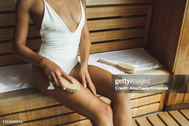 unrecognizable multiracial woman making anti cellulite or lymphatic thigh massage at sauna, closeup. - natural organic thermo cosmetics stock-fotos und bilder