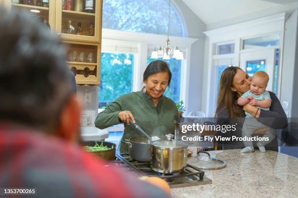 multi-ethnic group of adult friends preparing thanksgiving dinner in kitchen - indian food bildbanksfoton och bilder
