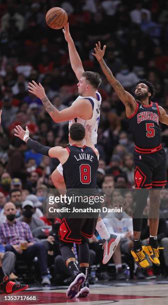 Luka Doncic of the Dallas Mavericks shoots between Zach LaVine and Derrick Jones Jr. #5 of the Chicago Bulls at the United Center on November 10,...