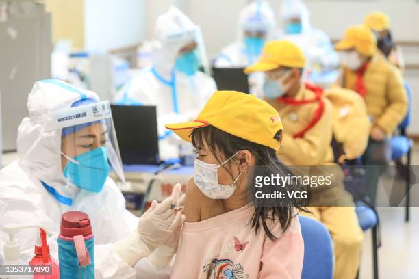 Child receives a dose of COVID-19 vaccine at a vaccination site on November 16, 2021 in Beijing, China. China has started COVID-19 vaccination for...