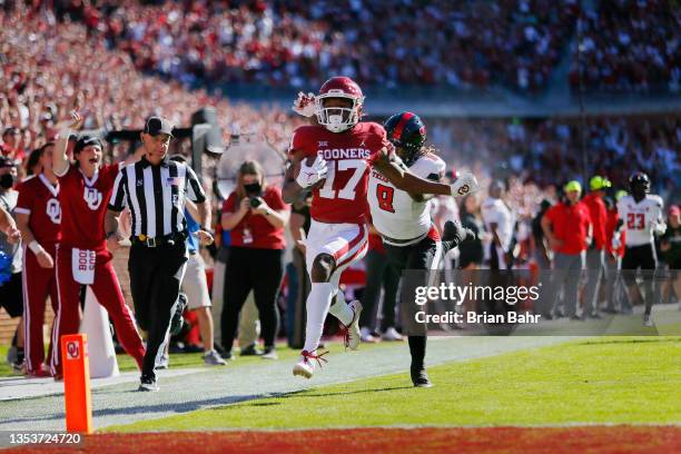 Wide receiver Marvin Mims of the Oklahoma Sooners sprints for a 67-yard touchdown off a catch past defensive back Malik Dunlap of the Texas Tech Red...