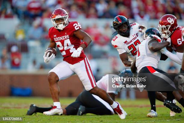 Running back Marcus Major of the Oklahoma Sooners slips past linebacker Riko Jeffers of the Texas Tech Red Raiders for a nine-yard gain only to pick...