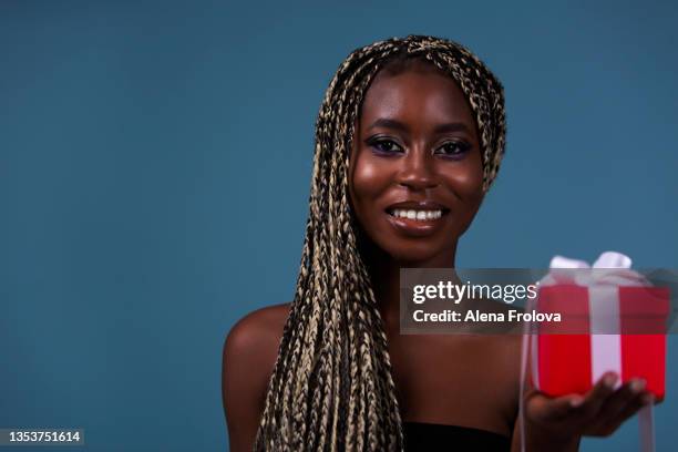 beautiful braided hair afro woman smiling and  holding gift box - african cornrow braids stock pictures, royalty-free photos & images