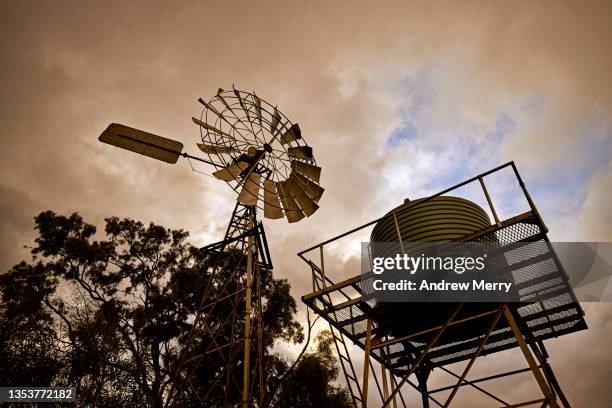 old farm windmill, water tower, clouds at sunset, rural australia - water tower storage tank - fotografias e filmes do acervo