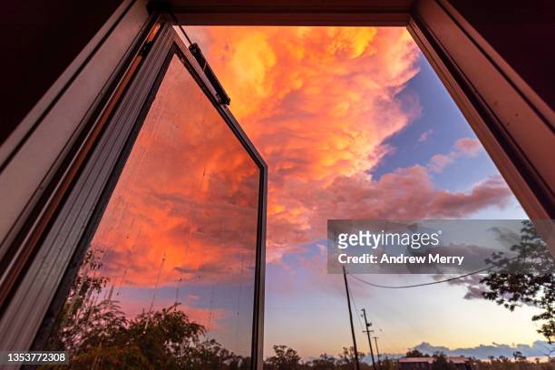 red sunset storm rain clouds, view from farm house door, rural australia - blue house red door stock pictures, royalty-free photos & images