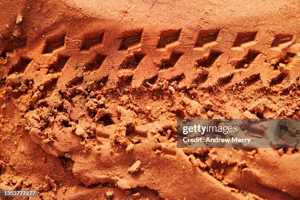 bicycle tyre track in mud, red dirt road outback australia - bicycle tire stockfoto's en -beelden