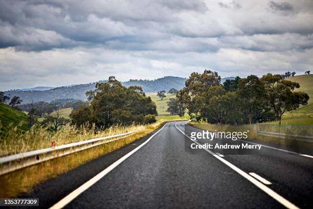 road trip, driving on empty highway, rain clouds, rural australia - new south wales road stock pictures, royalty-free photos & images