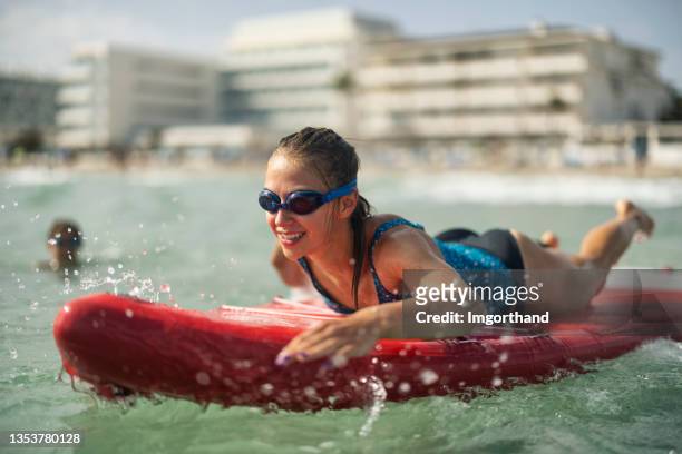 ragazza adolescente che si gode il paddleboard sup nel mare - surf board foto e immagini stock