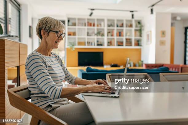 disfrutando de un día en casa - middle aged computer fotografías e imágenes de stock