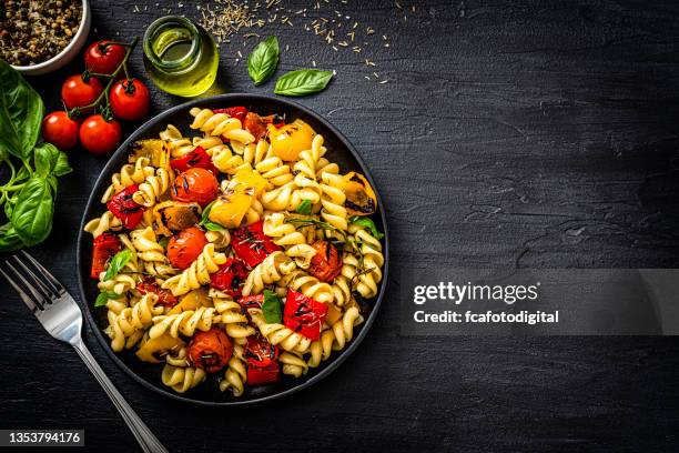 healthy pasta salad plate on black background - fusilli stock pictures, royalty-free photos & images