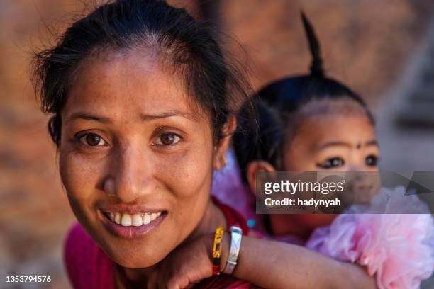 nepali young woman carrying her little daughter, bhaktapur, nepal - nepali mother stock pictures, royalty-free photos & images