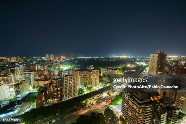 aerial view of elevated railway bridge passing through city at night - buenos aires rooftop stockfoto's en -beelden