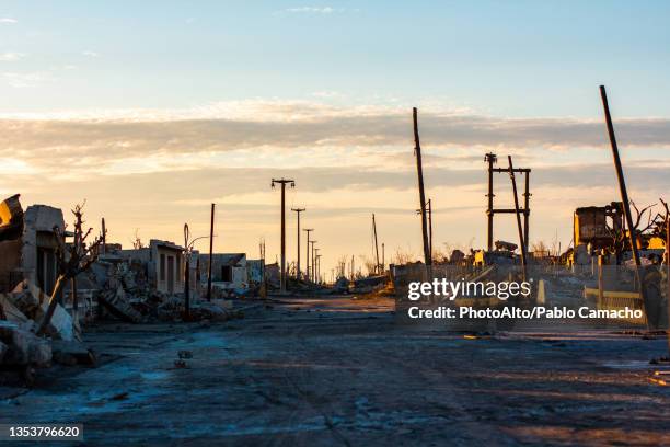 view of dirt road passing through abandoned village against cloudy sky, villa epecuen - argentina dirt road panorama stock pictures, royalty-free photos & images