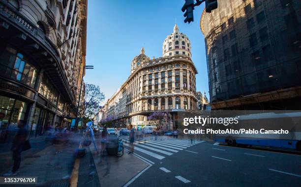 view of traffic and pedestrian on street with eclectic bencich building in background - buenos aires photos et images de collection