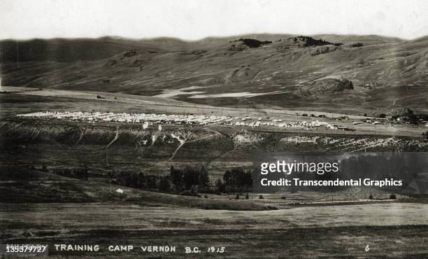 Large military training camp photographed from a distant hill is the subject of this 1912 postcard taken in Vernon, British Columbia, Canada.
