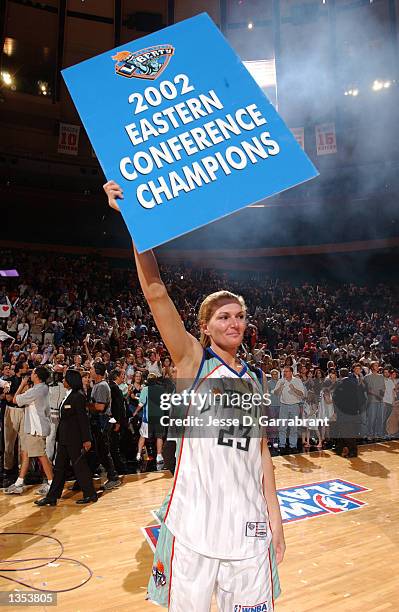 Sue Wicks of the New York Liberty holds up a 2002 Eastern Conference Champions sign following the Liberty's victory over the Washington Mystics in...
