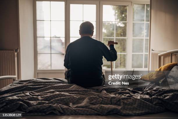 un homme seul est assis sur le lit - sad photos et images de collection