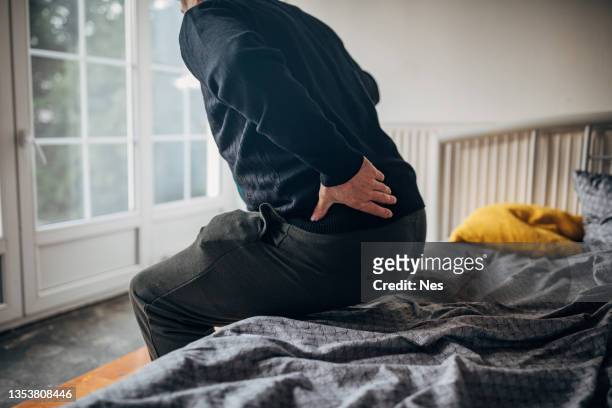 a man with lower back pain - lower stockfoto's en -beelden