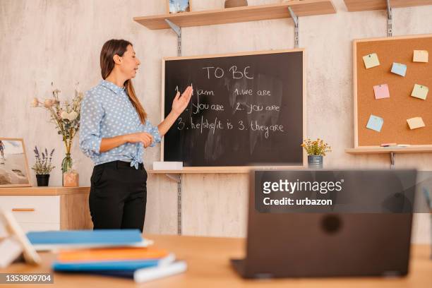 female teacher giving english language lesson online - english language stock pictures, royalty-free photos & images