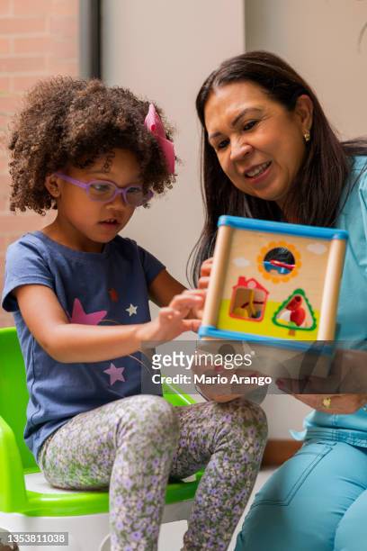 理学療法士の医師は、彼女の患者感覚療法の女の子に演習を行います - mental disability ストックフォトと画像