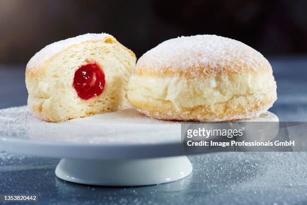 doughnuts with icing sugar and jam, whole and halved - beignet fourré photos et images de collection