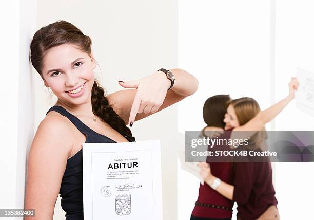 happy high-school graduate showing certificate - gymnasieexamen bildbanksfoton och bilder