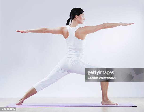 mid adult woman doing yoga against white background - wooden floor white background stock pictures, royalty-free photos & images