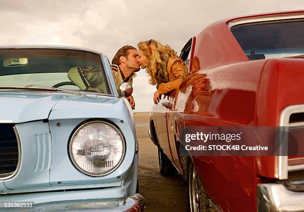 man and woman in two cars kissing - auto küssen stock-fotos und bilder