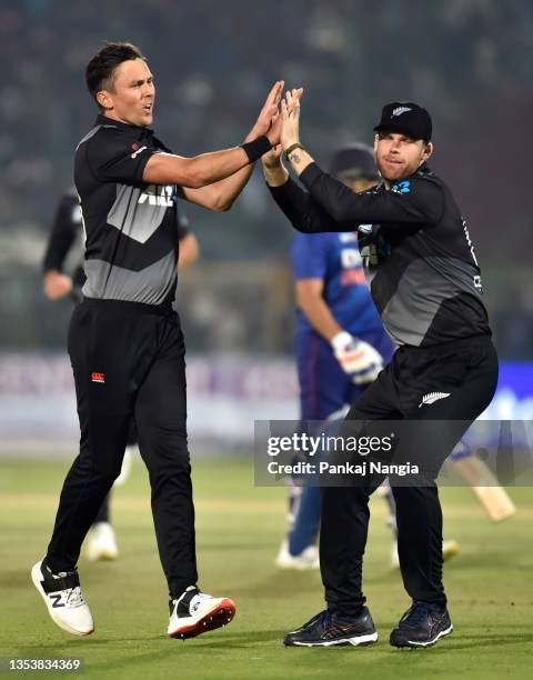 Trent Boult of New Zealand celebrates with teammate Lockie Ferguson after taking the wicket of Rohit Sharma of India during the T20 International...