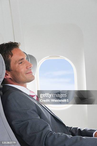 germany, bavaria, munich, mid adult businessman relaxing in business class airplane cabin - airplane seats stock pictures, royalty-free photos & images