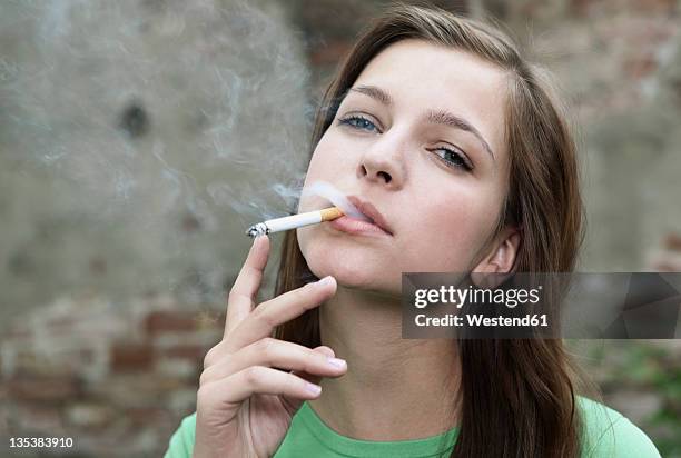 germany, berlin, close up of young woman smoking, portrait - beautiful women smoking cigarettes stockfoto's en -beelden