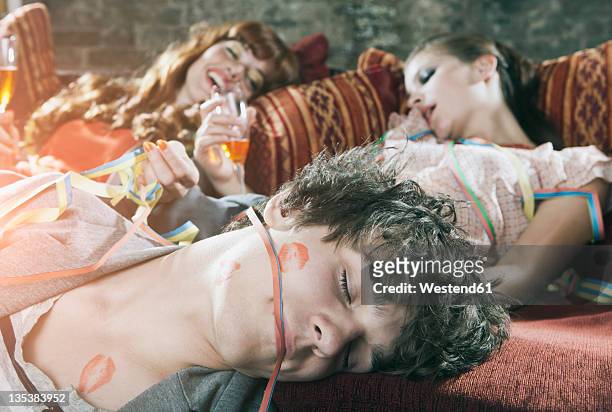 germany, berlin, close up of young man and women relaxing on couch after party - hangover after party stockfoto's en -beelden
