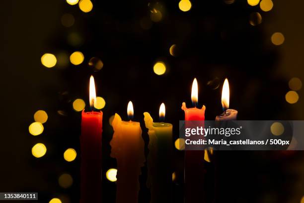 close-up of illuminated candles against illuminated lights - maria castellanos stock pictures, royalty-free photos & images